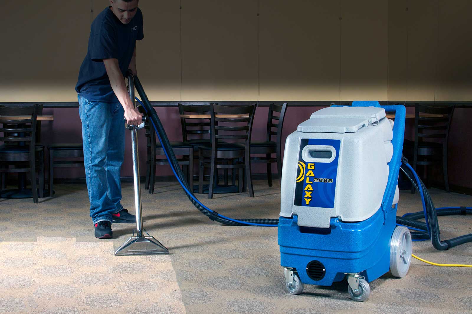 A Person Using a Vacuum to Clean A Carpet | Industrial Floor Cleaning Equipment